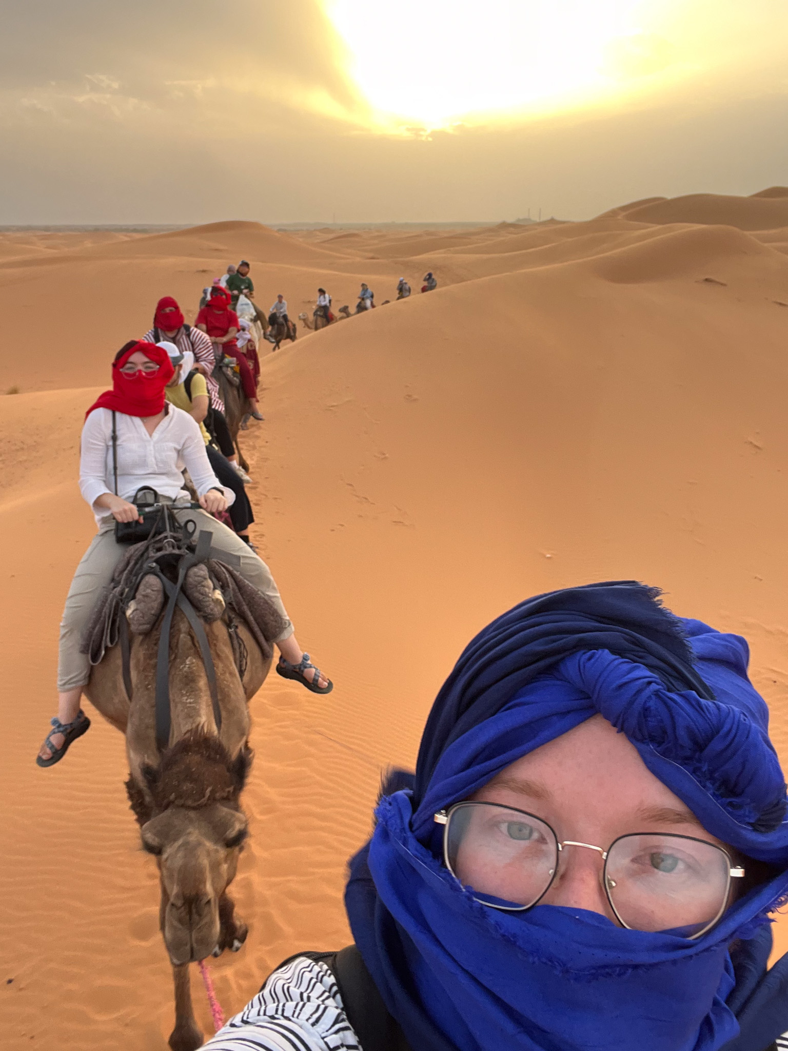 Image of Emily and other students riding a camel in the dessert