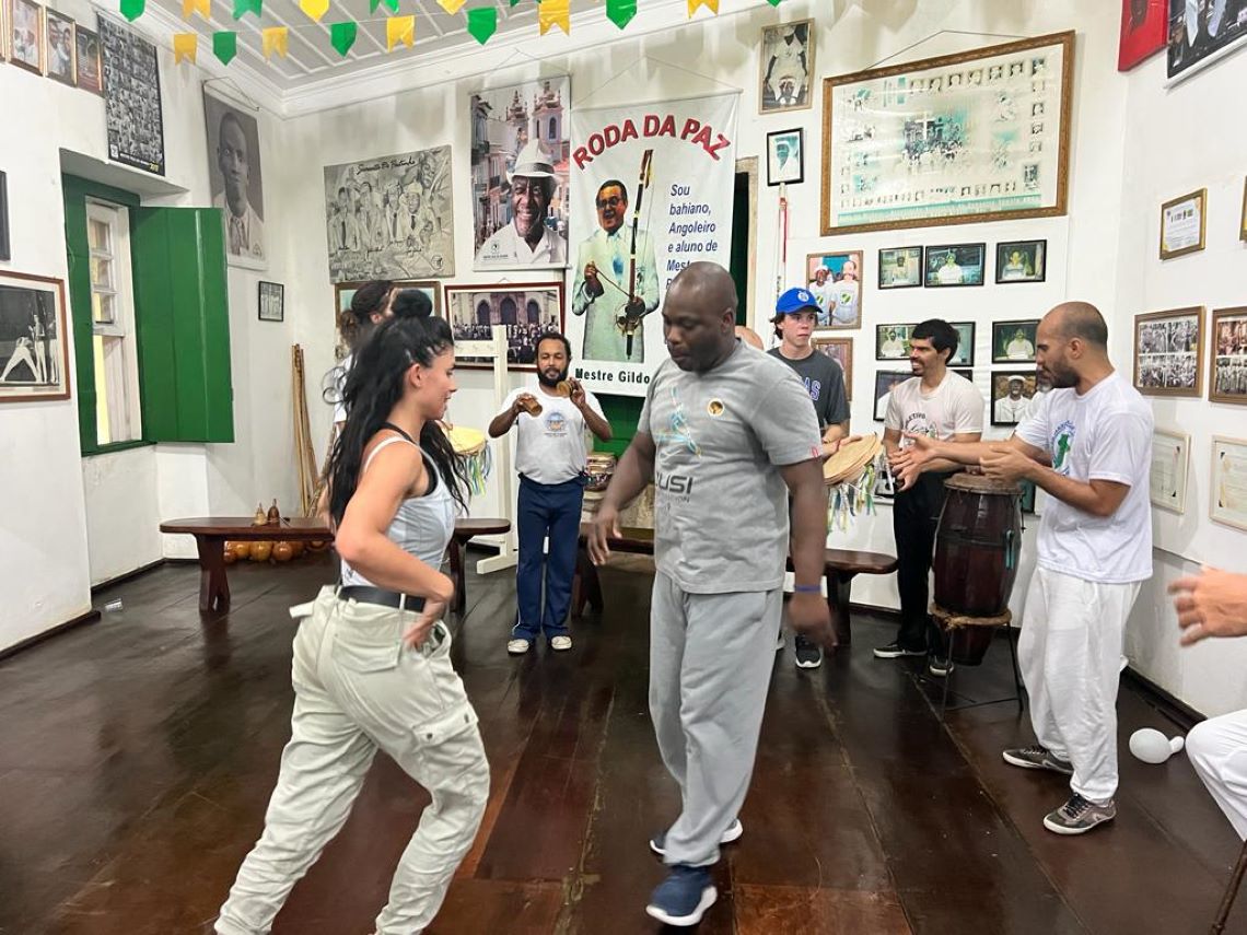 Adesoji and a woman practicing capoeira