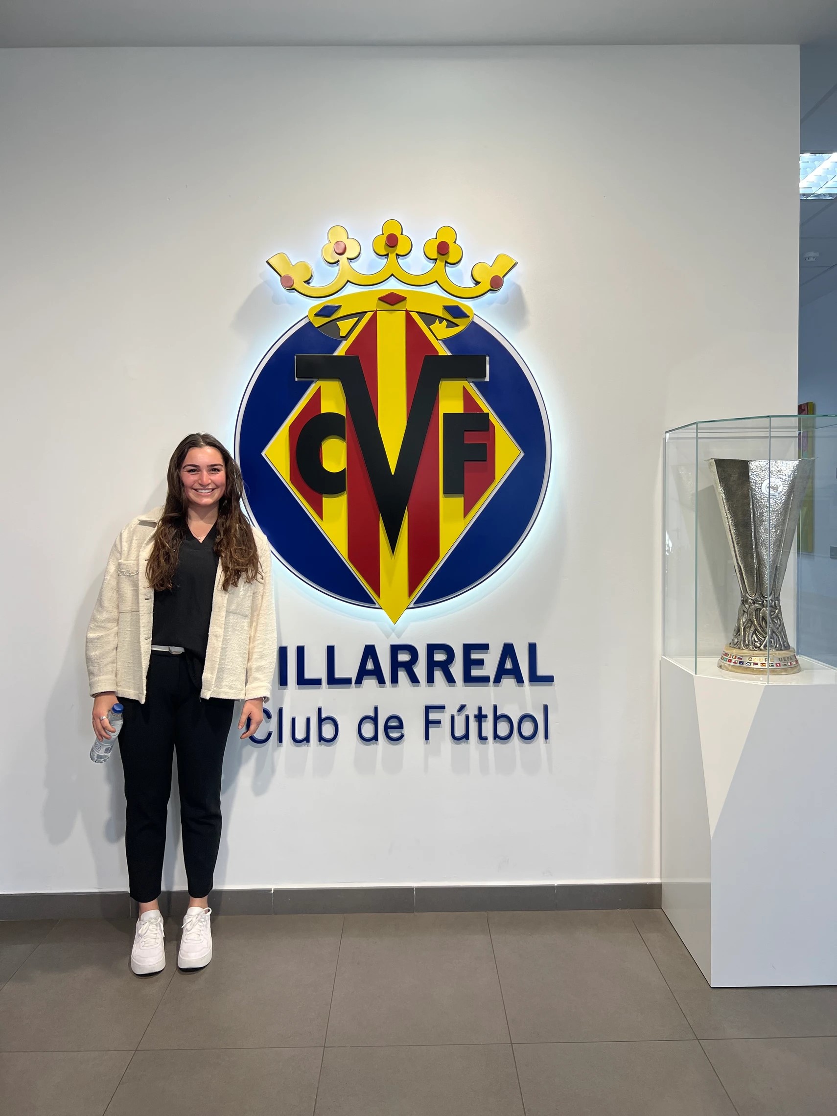 Ella in front of the Villarreal CF logo and the Europa league trophy