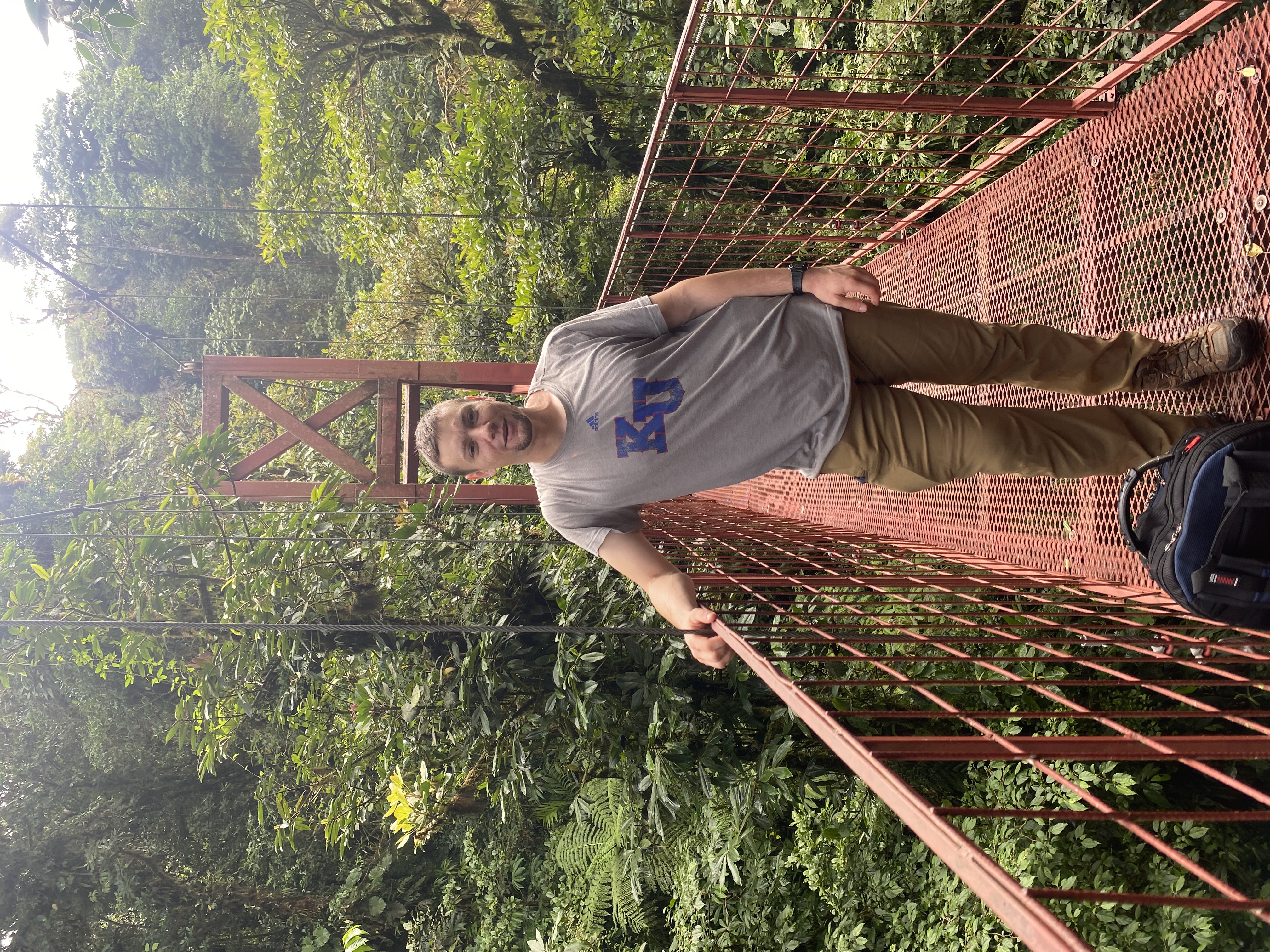 Image of James standing on a bridge in the rainforest.