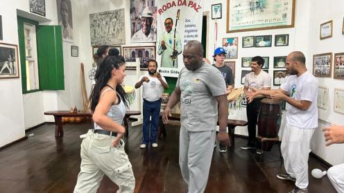 Adesoji and a woman practicing capoeira
